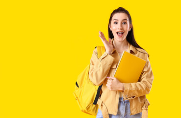 Portrait of excited female student on color background