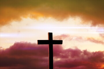 The wooden Cross at the sunset sky background