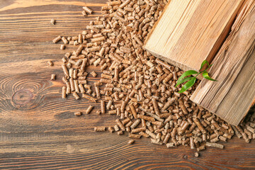 Heap of pellets with firewood on wooden background, closeup