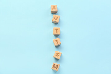 Wooden cubes with word AUTISM on blue background