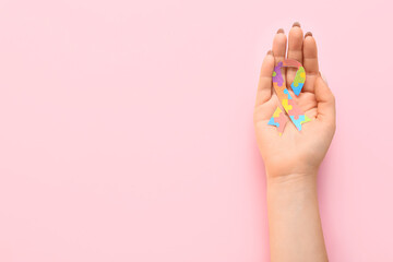 Woman with awareness ribbon on pink background. Concept of autistic disorder