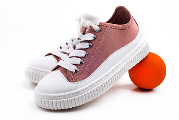 Children's pink sneakers, with a ball.  on white background.