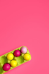 Holder with painted Easter eggs on color background, closeup