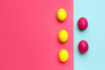 Painted Easter eggs on color background, top view