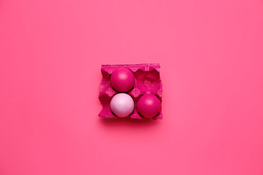 Holder with painted Easter eggs on color background