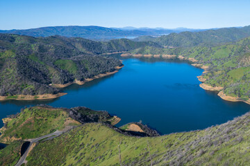 Fototapeta na wymiar Aerial vew of Lake Berryessa from the Blue Ridge Trail on a sunny day, featuring the reservour and the surrounding blue oak woodland