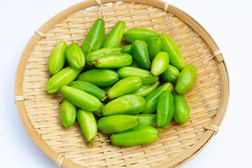 Bilimbi fruit in bamboo basket on white background.