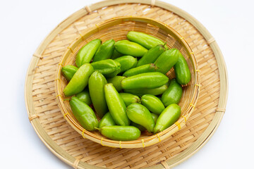 Bilimbi fruit in bamboo basket on white background.