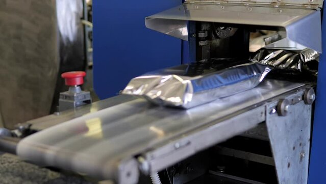 The plastic packaging machine on the production line packs food products. Humanitarian aid. Packaging of products at the enterprise.Robotic Production Line