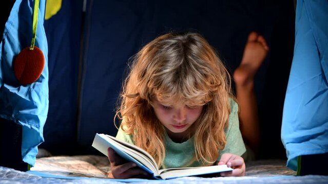 Child reading a book in the dark home. Happy childhood, dreaming child read bedtime stories, fairystory or fairytale.