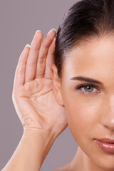 Taking your beauty advice. Beauty shot of a young woman with a cupped hand behind her ear.
