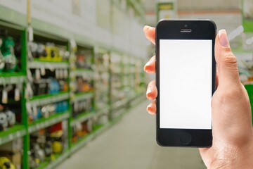 Hand with blank smartphone screen on Wine shop with bottles background.  Buying and ordering alcoholic