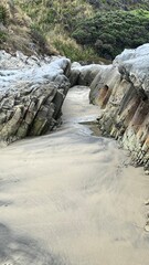 Fototapeta na wymiar Rock formations on Mangawhai Heads surf beach in NZ. 