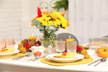 Autumn table setting with floral decor and pumpkins indoors