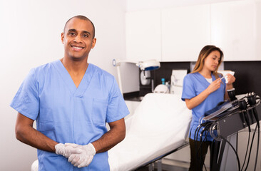 Smiling professional Latin American male cosmetician meeting patient in modern clinic of aesthetic medicine