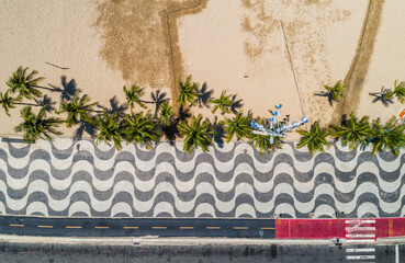 Aerial top view of Copacabana Beach sidewalk with palms and bicycle path, Rio De Janeiro, Brazil