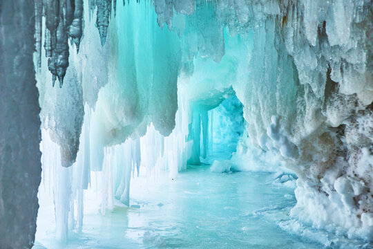 Narrow blue cave of ice in winter