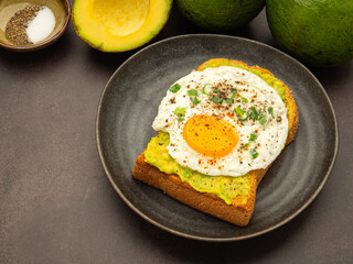 Toast with avocado and eggs served on a wooden cutting board