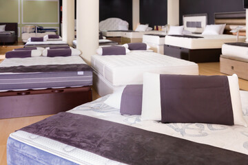 Closeup of pillows on modern comfortable stylish orthopedic mattress on display for sale in...