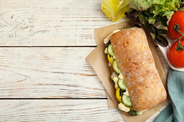 Delicious sandwich with vegetables, ham and mayonnaise on white wooden table, flat lay. Space for...