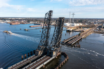Railroad bridge in the vertical position as a tug and barge pass through