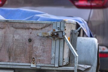 Transportation safety lock of a car trailer: Close-up detail of tarp and lock