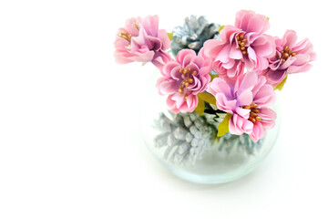 Artificial flower and glass vase with silver cone on white background, wedding interior detail close up