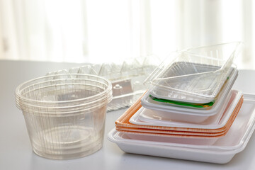 白いテーブルの上に積み重ねられたさまざまな種類のプラスチック容器