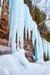 Winter rocky cliffs with large blue ice formations