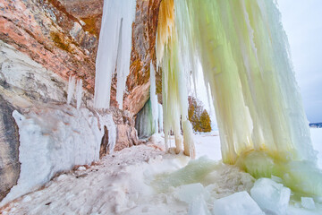 Giant sheets of icicles touching the ground next to cliffs