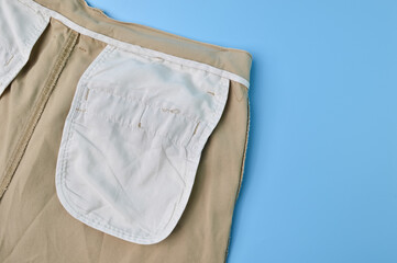 Close up view of a pant pocket isolated on a blue background. Fashion design concept