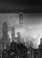 foggy night view of Victoria harbor in Hong Kong city