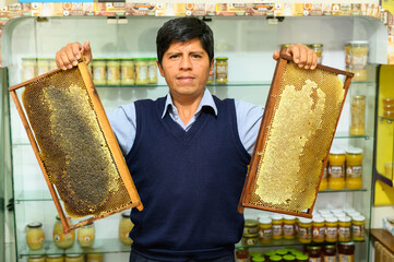 Beekeeper is teaching bee hive frames in his honey shop. Beekeeping.