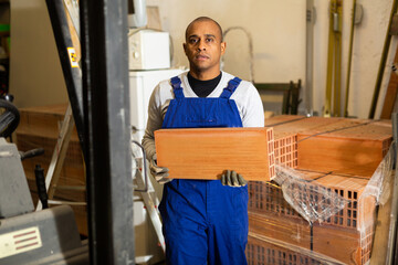 Male worker stacks insulation panels in a store