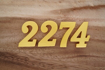 Golden Arabic numerals on a real brown and white wooden floor number 2274