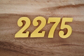 Golden Arabic numerals on a real brown and white wooden floor number 2275