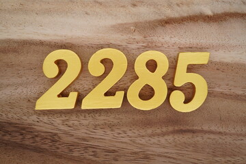 Golden Arabic numerals on a real brown and white wooden floor number 2285