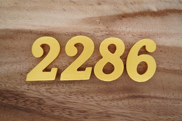 Golden Arabic numerals on a real brown and white wooden floor number 2286