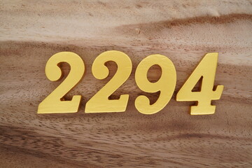 Golden Arabic numerals on a real brown and white wooden floor number 2294