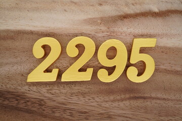 Golden Arabic numerals on a real brown and white wooden floor number 2295