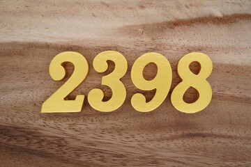 Golden Arabic numerals on a real brown and white wooden floor number 2398