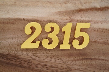 Golden Arabic numerals on a real brown and white wooden floor number 2315