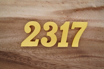 Golden Arabic numerals on a real brown and white wooden floor number 2317