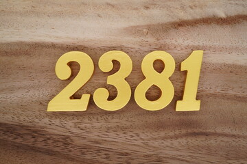 Golden Arabic numerals on a real brown and white wooden floor number 2381