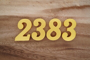 Golden Arabic numerals on a real brown and white wooden floor number 2383