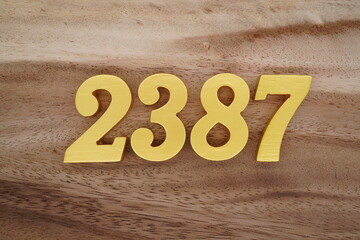 Golden Arabic numerals on a real brown and white wooden floor number 2387