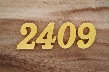 Golden Arabic numerals on a real brown and white wooden floor number 2409
