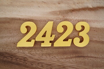 Golden Arabic numerals on a real brown and white wooden floor number 2423