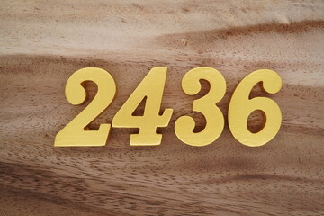 Golden Arabic numerals on a real brown and white wooden floor number 2436
