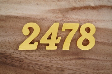Golden Arabic numerals on a real brown and white wooden floor number 2478